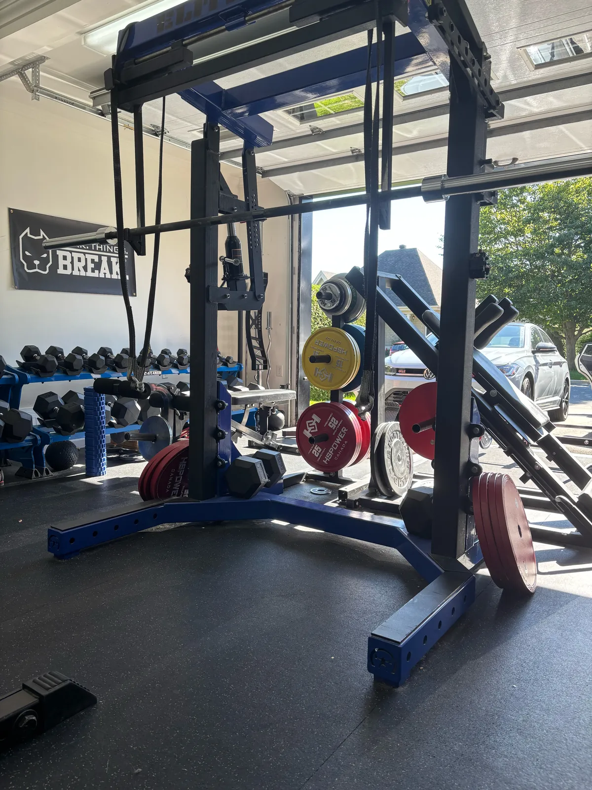 Le gym privé à Sorel-Tracy, avec la porte de garage et les racks d’entraînement.